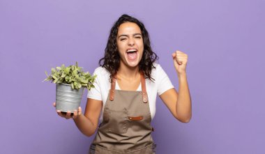 Genç İspanyol kadın öfkeli bir ifadeyle ya da yumruklarıyla saldırganca bağırıyor başarıyı kutluyor.