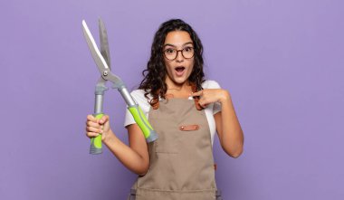 Genç İspanyol kadın mutlu, şaşkın ve gururlu hissediyor. Heyecanlı ve şaşkın bir bakışla kendini işaret ediyor.