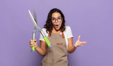 Genç İspanyol kadın ağzı açık ve şaşkın, şok olmuş ve hayretler içinde inanılmaz bir sürprizle