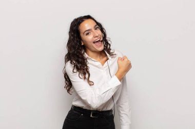 Genç İspanyol kadın mutlu, pozitif ve başarılı hissediyor, meydan okumayla karşılaştığında motive oluyor veya iyi sonuçları kutluyor.