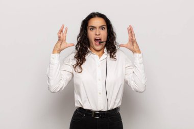 Genç İspanyol kadın ellerini havaya kaldırıp bağırıyor. Öfkeli, sinirli, stresli ve üzgün.