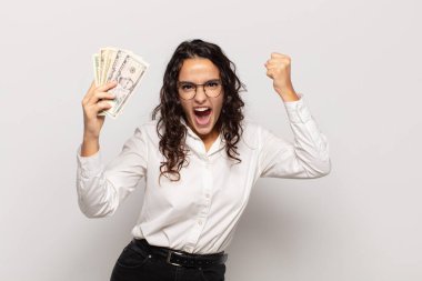 Genç İspanyol kadın öfkeli bir ifadeyle ya da yumruklarıyla saldırganca bağırıyor başarıyı kutluyor.