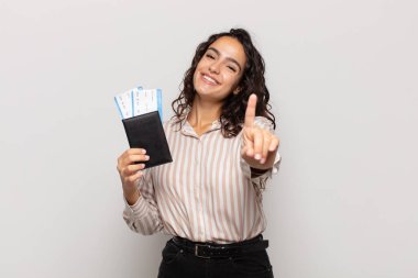 Genç İspanyol kadın gururla ve kendinden emin bir şekilde gülümsüyor. Bir numaralı pozu başarıyla veriyor. Kendini lider gibi hissediyor.