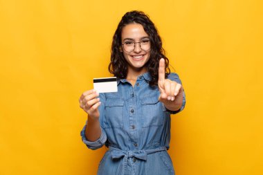 Genç İspanyol kadın gülümsüyor ve arkadaş canlısı görünüyor, bir numara veya ilk eli önde, geriye doğru sayıyor.