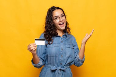 Genç İspanyol kadın mutlu, şaşırmış ve neşeli hissediyor, olumlu bir tavırla gülümsüyor, bir çözüm ya da fikri fark ediyor.