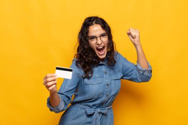 Genç İspanyol kadın öfkeli bir ifadeyle ya da yumruklarıyla saldırganca bağırıyor başarıyı kutluyor.