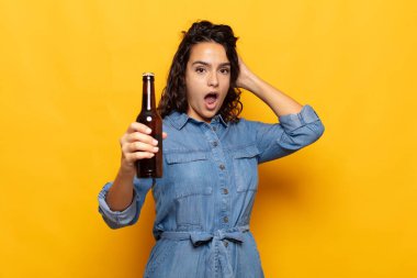 Genç İspanyol kadın kendini stresli, endişeli, endişeli ya da korkmuş hissediyor. Elleri başının üstünde, hatayla panikliyor.