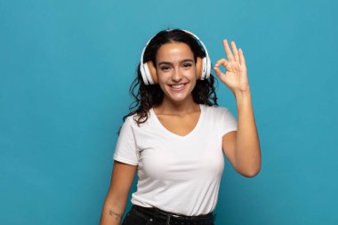 Genç İspanyol kadın kendini mutlu, rahat ve tatmin olmuş hissediyor. Onayını iyi bir hareketle gösteriyor. Gülümsüyor.