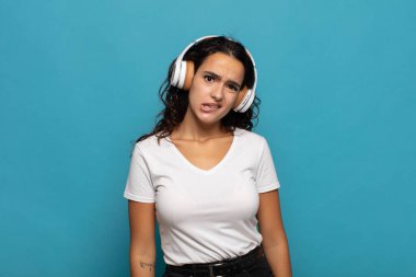 Genç İspanyol kadın şaşkın ve şaşkın görünüyor. Sinirli bir hareketle dudağını ısırıyor. Sorunun cevabını bilmiyor.