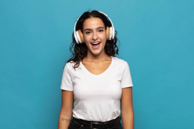 Genç İspanyol kadın mutlu ve hoş bir şekilde şaşırmış görünüyor. Büyülenmiş ve şok olmuş bir ifadeyle heyecanlanıyor.