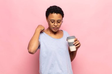 Genç siyah afro kadın stresli, endişeli, yorgun ve hayal kırıklığına uğramış, gömleğini çekiştirip duruyor.