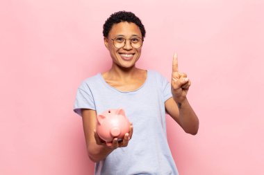 Genç siyah afro kadın gülümsüyor ve arkadaş canlısı görünüyor, bir numara veya ilk eli önde, geriye doğru sayıyor.