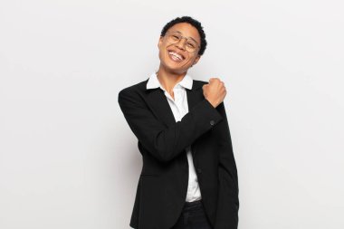 Genç siyah afro kadın mutlu, pozitif ve başarılı hissediyor, bir meydan okumayla karşılaştığında motive oluyor veya iyi sonuçları kutluyor.