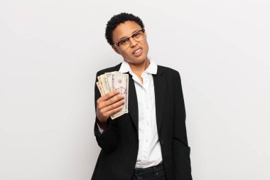 young black afro woman feeling puzzled and confused, with a dumb, stunned expression looking at something unexpected