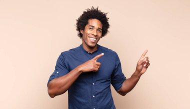 Profil görünümlü genç siyah afro adam uzayı kopyalamaya çalışıyor, düşünüyor, hayal ediyor ya da hayal kuruyor.