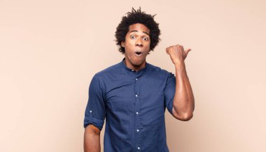 Genç siyah afro adam inanılmaz bir başarıyı kutluyor. Kazanan gibi, heyecanlı ve mutlu görünüyor. Al bunu.!