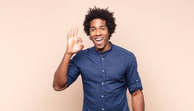 Genç siyah afro adam ciddi görünüyor, kafası karışık, kararsız ve düşünceli, seçenekler ve seçimler arasında şüpheci