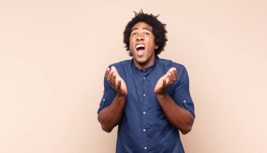 Genç siyah afro adam gururlu, pozitif ve iki eliyle göğsünü gösteren