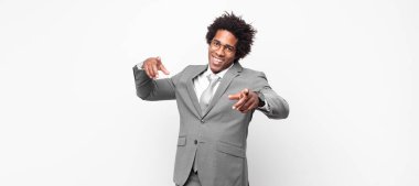 Siyah afro iş adamı mutlu ve kendinden emin, kamerayı iki eliyle gösteriyor ve gülüyor, seni seçiyor.