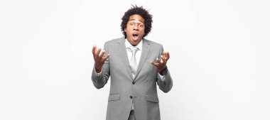 Siyah afro iş adamı ağzı açık ve şaşkın, şok olmuş ve hayretler içinde inanılmaz bir sürprizle