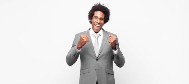 Siyahi afro iş adamları zaferle bağırıyor, gülüyor, mutlu ve heyecanlı hissediyorlar.