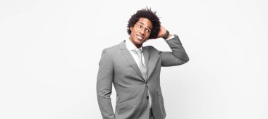 Siyah afro iş adamı neşeli ve gelişigüzel gülümsüyor, olumlu, mutlu ve kendinden emin bir bakışla göğüs göğüse tutuşuyor.