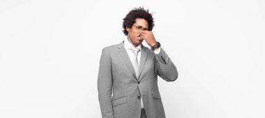 Siyah afro iş adamı tiksinti duyuyor, pis ve nahoş bir kokuyu koklamamak için burnunu tutuyor.