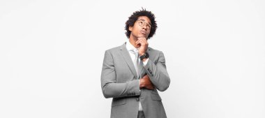 Siyah afro iş adamı düşünceli, meraklı ya da hayal kuran, hayal kuran ve mekanı kopyalamak isteyen