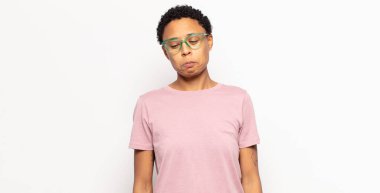 Afro genç siyahi kadın üzgün ve mızmız, mutsuz bir bakışla, olumsuz ve hayal kırıklığına uğramış bir tavırla ağlıyor.