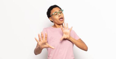 Afro genç siyahi kadın korkmuş hissediyor, korku ve panik içinde geri çekiliyor, kabusa tepki veriyor.