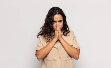 Güzel genç bir kadın endişeli, umutlu ve dindar hissediyor. Avuçlarına bastırılmış, af dileyen sadık bir şekilde dua ediyor.
