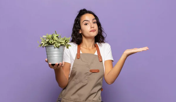 年轻的惊慌失措的女人感到困惑和困惑 权衡或以滑稽的表情选择不同的选择 — 图库照片