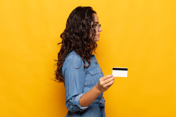 молодая испаноязычная женщина в профиль зрения ищет скопировать пространство впереди, думая, воображая или мечтая