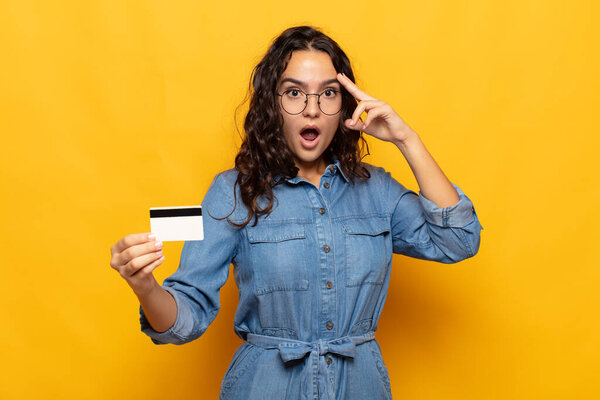 молодая испаноязычная женщина выглядит удивленной, открытой, шокированной, понимая новую мысль, идею или концепцию