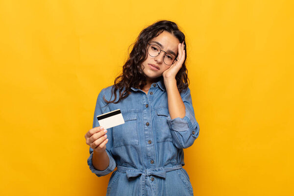 молодая латиноамериканка чувствует себя скучающей, расстроенной и сонной после утомительной, скучной и утомительной задачи, держа лицо за руку