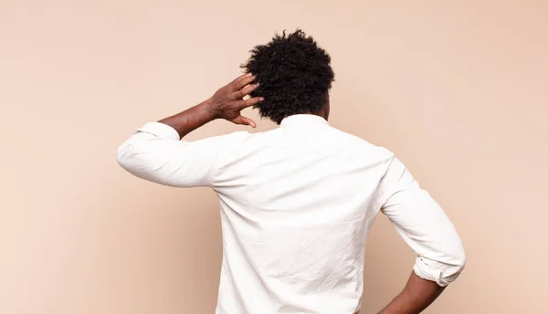 若い黒人アフロ男は頭の上に手を置いて解決策を考え混乱し混乱している — ストック写真