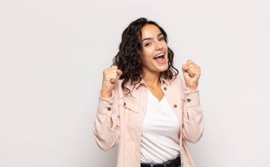 Güzel genç bir kadın şaşkın, heyecanlı ve mutlu hissediyor, gülüyor ve başarıyı kutluyor, vay canına diyor.!