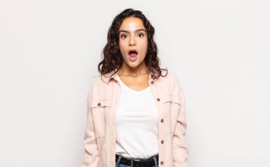 Güzel genç bir kadın şok olmuş ya da şaşırmış görünüyor, ağzı açık bir şekilde 