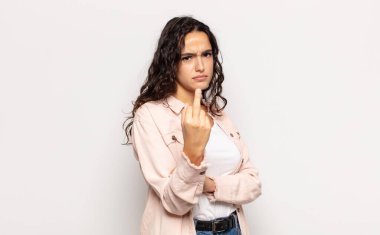 Güzel genç bir kadın kızgın, sinirli, asi ve agresif hissediyor, orta parmağını sallıyor, karşı koyuyor.