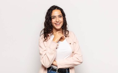 Güzel genç bir kadın gülümsüyor, hayattan zevk alıyor, mutlu, arkadaş canlısı, tatmin olmuş ve tasasız.