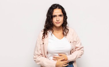 Güzel genç bir kadın endişeli, hasta, hasta ve mutsuz hissediyor. Ağrılı bir mide ağrısı ya da grip geçiriyor.