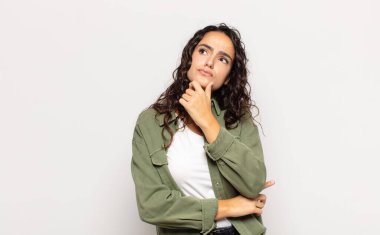 Düşünen, kuşkulu ve kafası karışık, farklı seçenekleri olan, hangi kararı vereceğini merak eden genç bir kadın.
