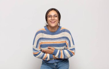 Güzel, genç bir kadın komik bir şakaya yüksek sesle gülüyor, mutlu ve neşeli hissediyor, eğleniyor.