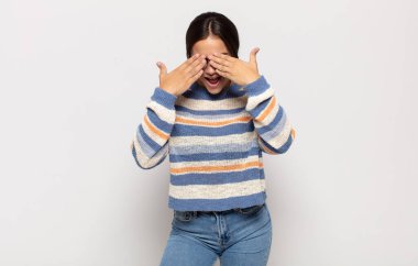 Güzel genç bir kadın gülümsüyor ve mutlu hissediyor, iki eliyle gözlerini kapatıyor ve inanılmaz bir sürpriz bekliyor.