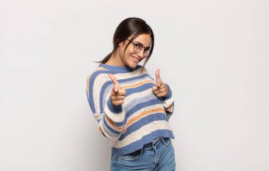 Güzel genç bir kadın kendini mutlu, sakin, tatmin olmuş, rahat ve başarılı hissediyor, kameraya bakıyor, seni seçiyor.