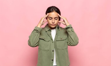 Güzel genç bir kadın konsantre, düşünceli ve ilham verici, beyin fırtınası yapıyor ve hayal ediyor.