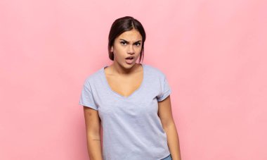 Şok olmuş, kızgın, sinirli ya da hayal kırıklığına uğramış, ağzı açık ve öfkeli genç bir kadın.