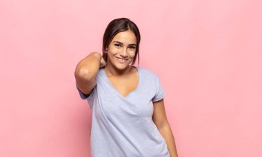 Güzel, genç bir kadın neşeli ve kendinden emin bir şekilde gülüyor. Sıradan, mutlu, dostane bir gülümsemeyle.