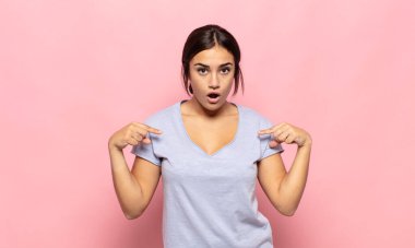 Güzel, genç bir kadın gururlu, pozitif ve iki eliyle göğsünü gösteren