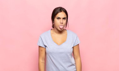 Güzel genç bir kadın tiksinti ve tedirginlik duyuyor, dilini dışarı çıkarıyor, iğrenç ve iğrenç bir şeyden hoşlanmıyor.